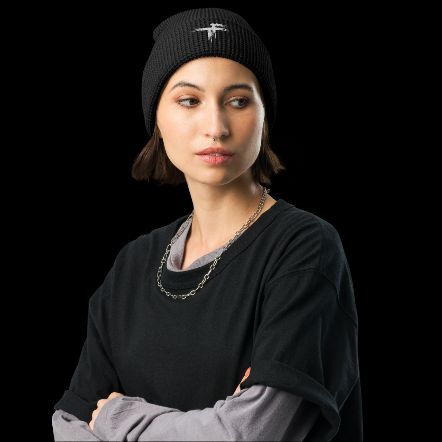 Woman wearing a black beanie and black sweater with arms crossed